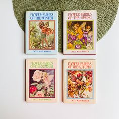 four children's books about flower fairies on a green rug next to a hat