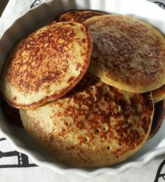 three pancakes in a white bowl on a table