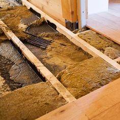 an unfinished room with wood flooring and exposed pipes in the floor that have been removed