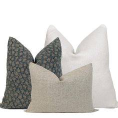 three pillows with different patterns on them, one in blue and the other in white