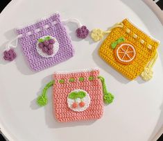 three crocheted purses sitting on top of a white plate