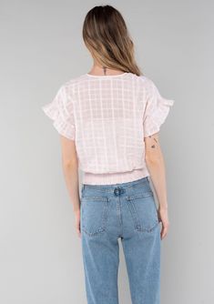 Welcome warmer weather with this effortless bohemian cotton top. Designed in a subtle textured gingham, this classic boho style features short flutter sleeves, a surplice wrap front, and a smocked elastic hemline. Perfect for transitioning from the beach to a night out! Textured gingham Relaxed fit Ruffled short sleeve Surplice v-neckline Hook & eye closure Smocked elastic waist Sheer Lining included Cotton bohemian top Model is 5'8, wearing a size S in White. Model is 5'10, wearing a size XS in Cotton Smocked Top With Flutter Sleeves For Spring, Casual Peasant Top With Flutter Sleeve And Ruffles, Spring Casual Peasant Top With Flutter Sleeve, Feminine Cotton Smocked Top With Short Sleeves, Bohemian Smocked Top With Ruffles And Short Sleeves, Bohemian Cotton Smocked Top With Ruffles, Bohemian Smocked Cotton Top With Ruffles, Casual Cotton Smocked Top With Ruffle Sleeves, Bohemian Tops With Elastic Waistband For Spring