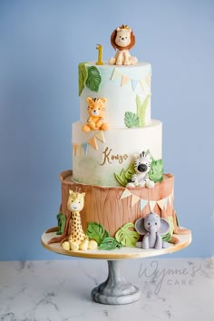 a three tiered cake with animals on it