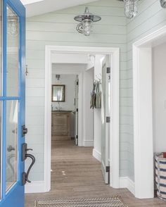 an open door leading to a hallway with white walls and wood flooring on the other side