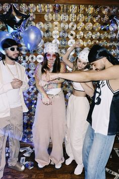 a group of people standing next to each other in front of balloons and confetti