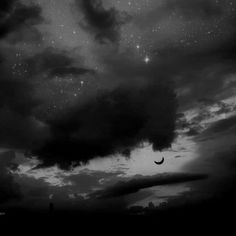 black and white photograph of the night sky with clouds, stars and moon in the distance