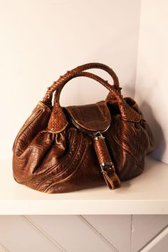 Vintage Fendi spy bag from the mid-aughts. Bag is made in distressed brown leather with woven handle, interior clasp pocket, interior yucca canvas fabric. In excellent condition. Length: 11.7" Width: 18" Depth: 8" Label: FENDI All of my items are all vintage. I strive for the best quality and condition possible, and to accurately describe condition of items that are not in perfect condition. Please refer to the rating system before purchase!  RATING SYSTEM: Excellent: New with or without tags Very good: Like new Good: In overall good condition, but with minor wear or with some small repairs As-is: Some wear to be noted, sold at lower price due to noteworthy flaws or notable repairs Poor: Isn't in great condition, can be used for design and is sold lower due to said condition Spy Bag Fendi, Handheld Textured Leather Brown Satchel, Vintage Fendi Baguette Outfit, Fendi Baguette Outfit, Fendi Vintage Bag, Vintage Fendi Baguette, Fendi Spy Bag, Alaia Bag, Vintage Fendi Bag