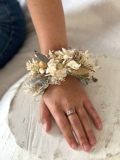 a close up of a person's hand wearing a bracelet with flowers on it