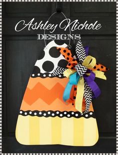 a door hanger decorated with an orange and black dress