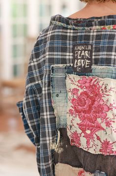 the back of a woman's shirt with patchwork and floral designs on it