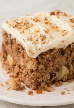 a close up of a piece of cake on a plate with frosting and nuts