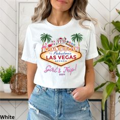 a woman wearing a white t - shirt with the las vegas sign on it