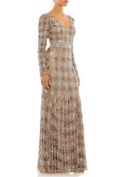 A lattice pattern of shimmering sequins illustrates an alluring gown with a plunging neckline and a sweeping train for a showstopping stunner. V-neck Long sleeves V-back Lined 100% polyester Spot clean Imported Asian Owned/Founded Bronze Dress, Gown Gold, Mac Duggal Dresses, Trumpet Skirt, Trumpet Gown, Long Sleeve Evening Dresses, Long Sleeve Sequin, Mac Duggal, Long Sleeve Gown