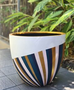 a striped pot is sitting on the ground