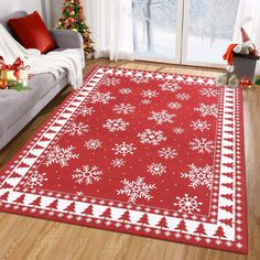 a red and white rug with snowflakes on it in front of a couch