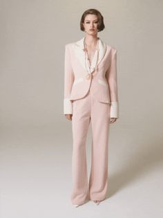 a woman in a pink suit and pearls