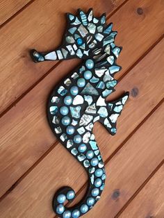 a seahorse made out of shells on a wooden floor