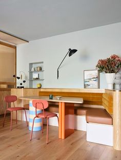 two chairs and a table in a room with wood flooring next to a wall