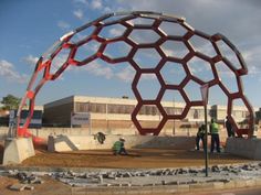 two men standing in front of a large metal structure