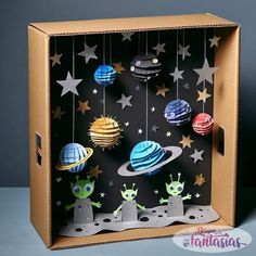 an open cardboard box with paper cut out of the outer planets and stars hanging from it