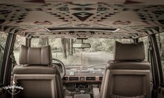 the interior of a vehicle with native designs on the ceiling and dash board, along with leather seats