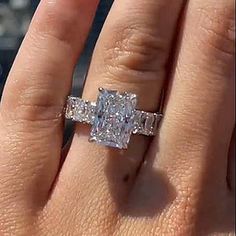 a woman's hand with a diamond ring on it