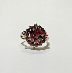 Estate Victorian Bohemian Garnet 2 Tiered Split Shank 14k YG & Silver Ring Size 7Metal: 14k yellow gold, stampedsilver top, acid testedWeight: 4.4 gramsRing size: 7 (can be resized upon request)Size: Center is 16mm in diameter (at widest point)Shank tapers from 6.50mm to 4mm to 2.25mm on bottomStones: (1) 3.35mm center garnet,(6) 2.80mm garnets (one is slightly chipped),(14) 2.25mm garnetsHallmarked: 14kThis is an estate piece in excellent condition.  Please see pictures for reference. Antique Multi-stone Yellow Gold Cluster Ring, Antique 14k Yellow Gold Ruby Ring, Antique Multi-stone Cluster Ring In Yellow Gold, Gold Cluster Ruby Ring Hallmarked, Gold Cluster Ruby Ring, Hallmarked, 14k Gold Cluster Ring Hallmarked, Antique 14k Gold Cluster Jewelry, Collectible Yellow Gold Cluster Ring With Gemstone, Antique 14k Gold Cluster Ring With Gemstones