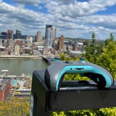 a video game controller sitting on top of a black box in front of a city