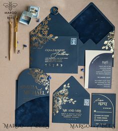 the wedding stationery is set up with blue and gold paper, calligraphy, and envelopes