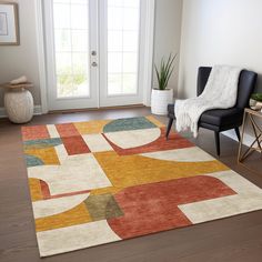 a living room area with a rug, chair and potted plant on the floor