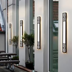 an outdoor area with benches and lights on the side of it, along with potted plants