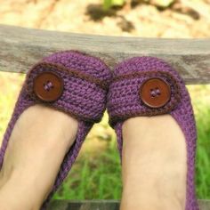 a pair of purple crocheted slippers with buttons