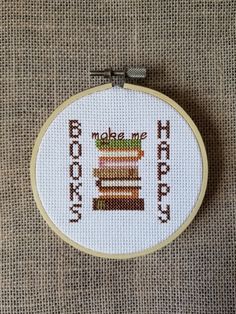 a cross - stitch pattern with the words make me happy and stacked books on it