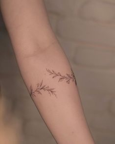 a woman's arm with two small flowers on the left side of her arm