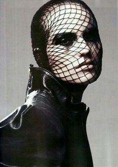 a man wearing a netted mask and leather jacket