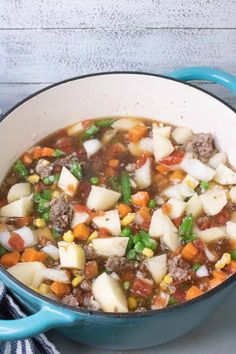 a blue pot filled with meat and vegetables