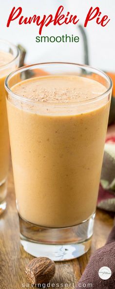 two glasses filled with pumpkin pie smoothie on top of a wooden table