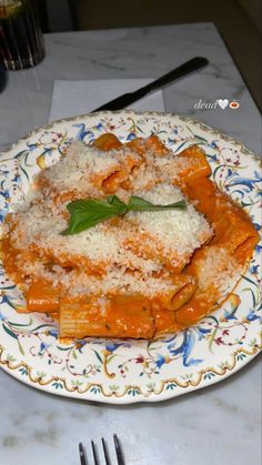 a plate topped with pasta covered in sauce and parmesan cheese