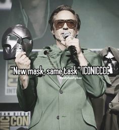 a man in a suit and sunglasses holding a microphone with the words new mask, same task