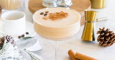 a close up of a drink in a wine glass on a table with other holiday decorations