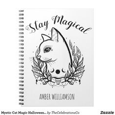 a spiral notebook with an image of a cat and leaves on the cover, which reads stay