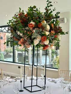 the centerpieces are arranged in black stands with flowers and greenery on them