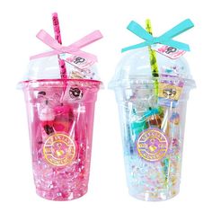 two plastic cups with straws in them and bows on the top one is filled with confetti