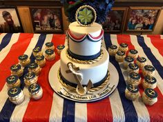 a cake and cupcakes are on a table with an american flag draped cloth