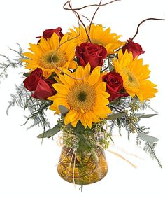 a vase filled with red roses and yellow sunflowers