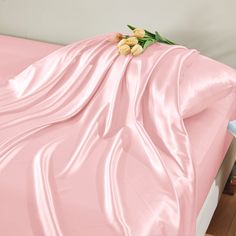 a bed covered with pink sheets and flowers