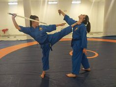 two women are practicing karate in an indoor gym