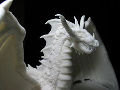 a white dragon statue sitting on top of a table