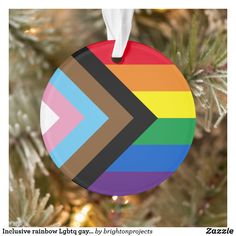 a colorful ornament hanging from a christmas tree with the colors of rainbow on it