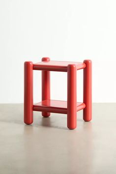 a small red table sitting on top of a cement floor